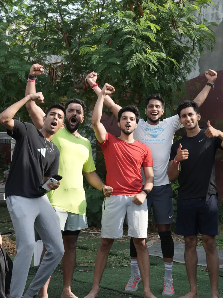 Participants with arms raised at the finish of the Hyrox-style simulation